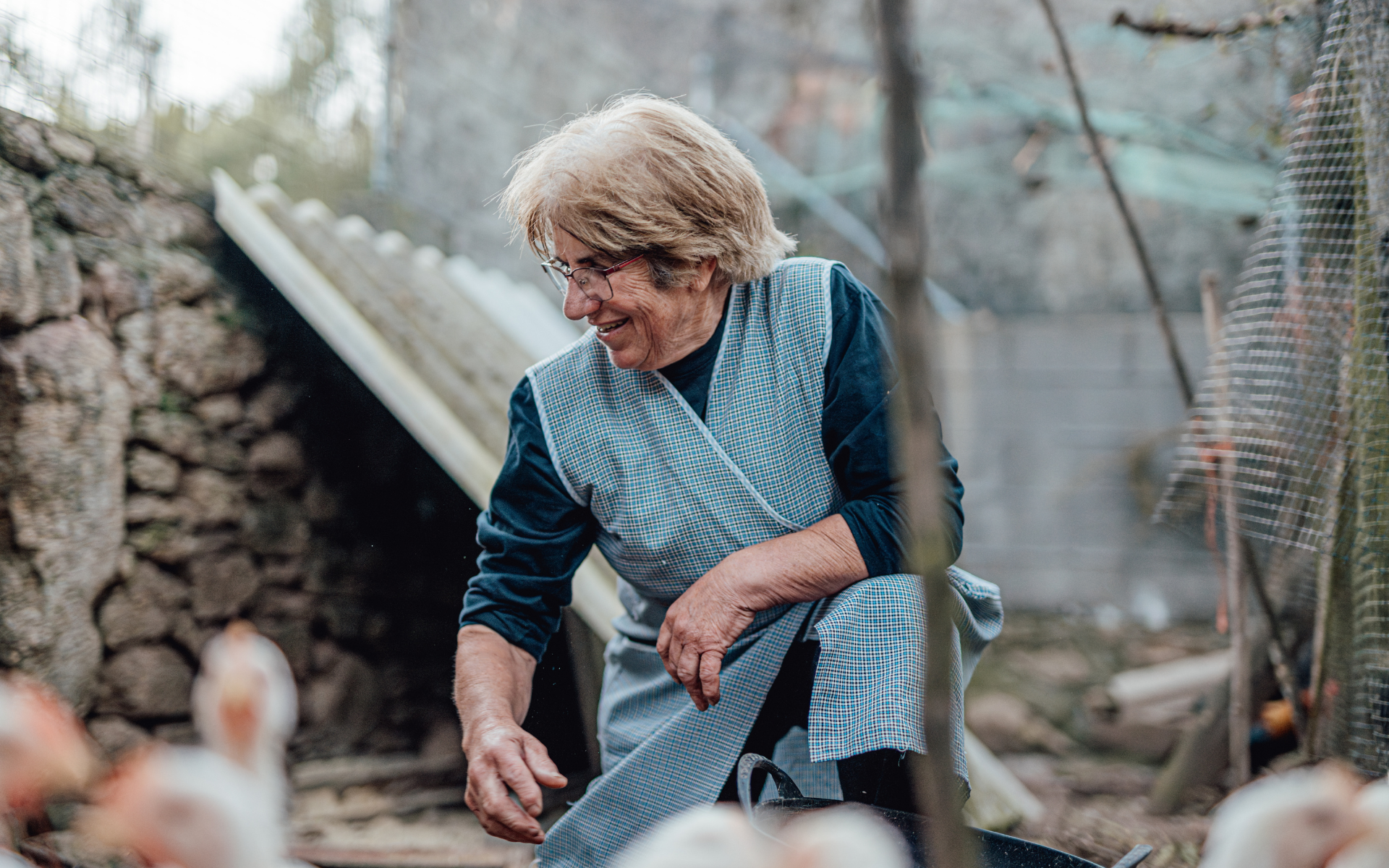 Image of Woman on farm with chickens blurred in the foreground