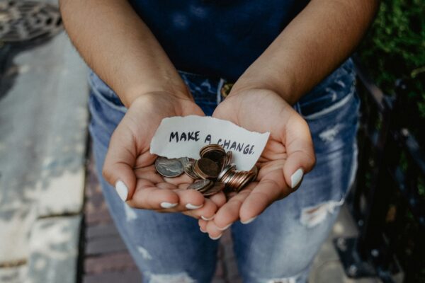 Persons holding various small change in their hands, she has white painted nails