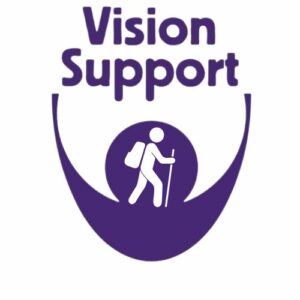Walking The Vision Support logo on a white background. The words "Vision Support" appear in bold purple text above the charity's purple logo. Inside the logo is a white icon of a person with a backpack using a long cane, representing independent mobility and walking with sight loss.